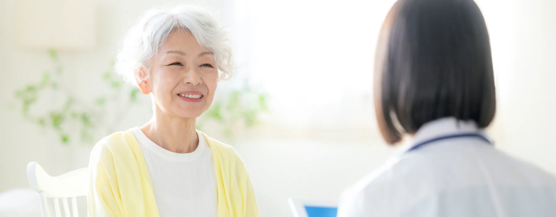相談する高齢の女性と医療スタッフ