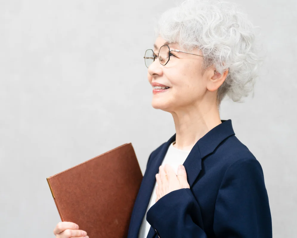ノートを手にほほえむ高齢の女性