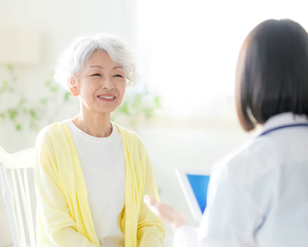 医療スタッフと向かい合って話す高齢の女性